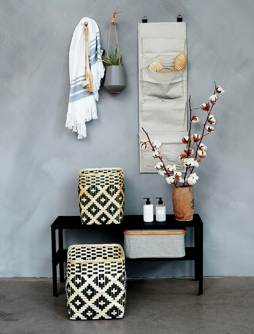 Hanging fabric organiser above black shelves with black and white storage baskets in the bathroom