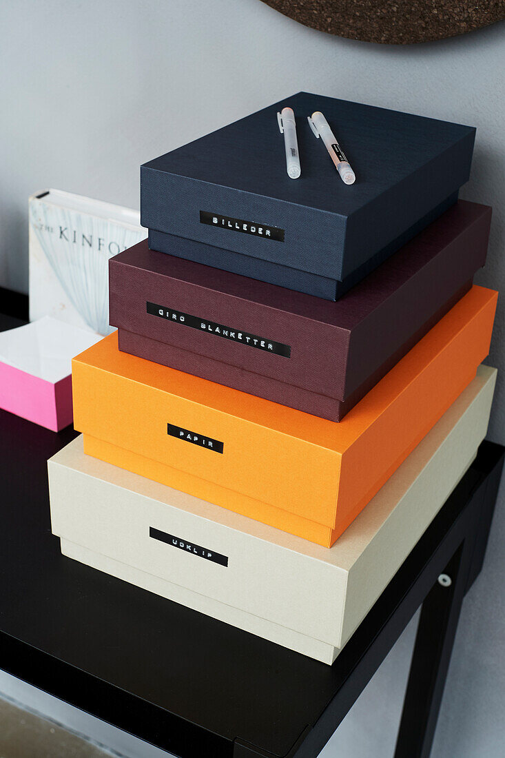 Stacked and labelled organiser boxes on desk