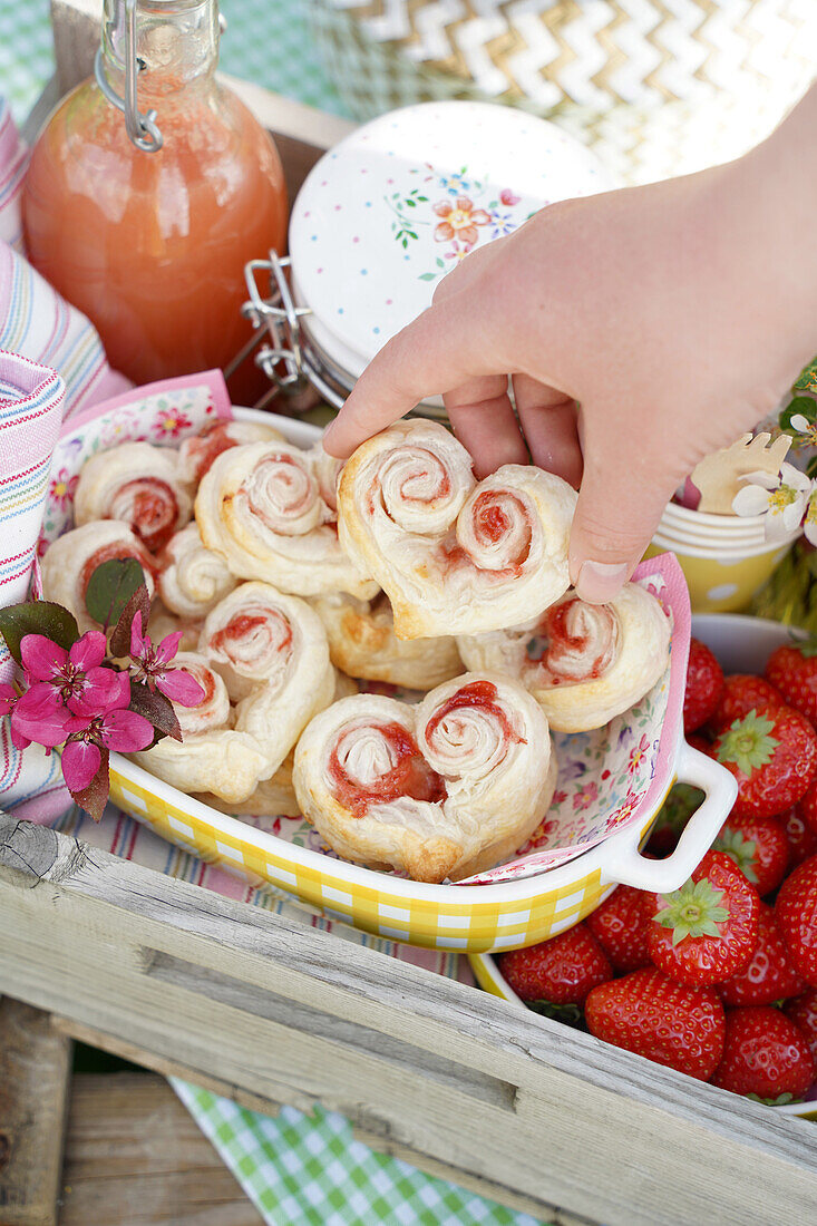 Pastries, strawberries, drink and preserving jar on a wooden tray