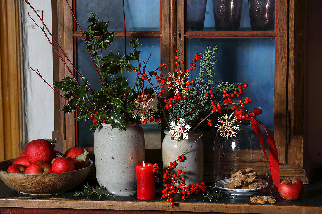 Winter arrangement on the windowsill with holly and apples