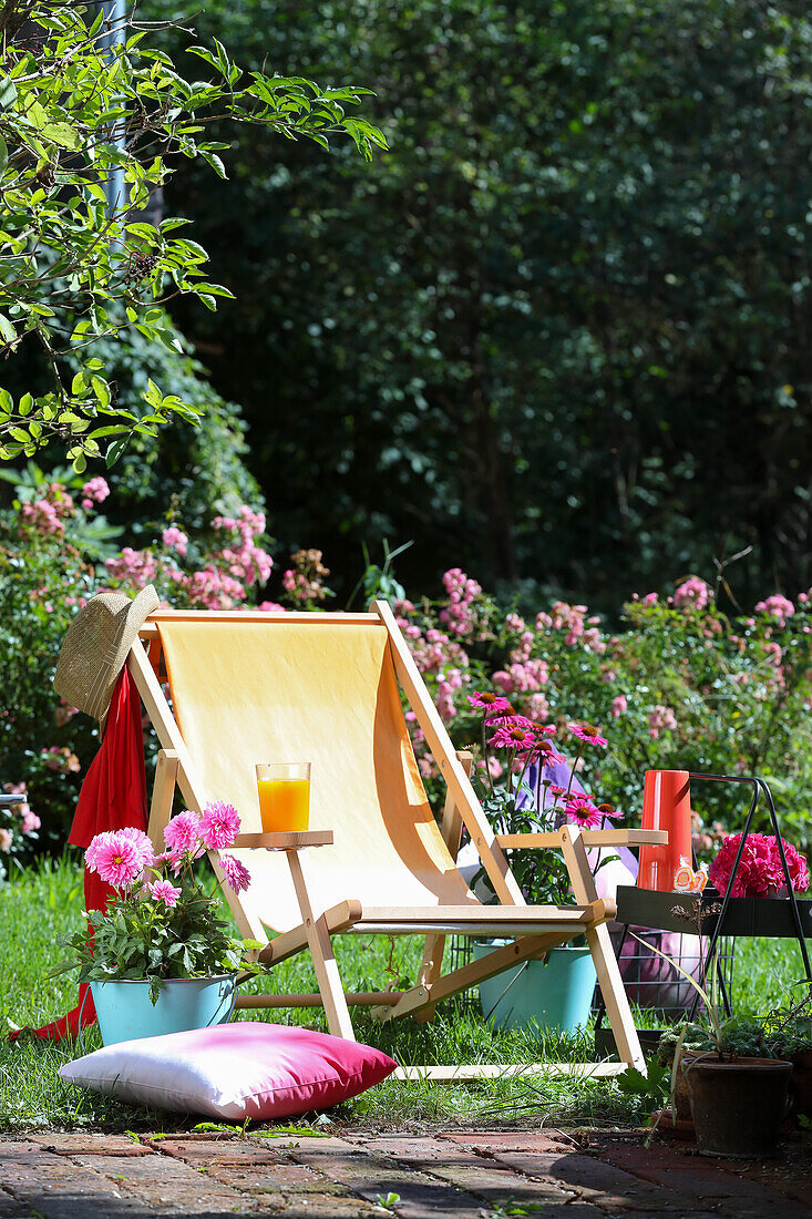 Liegestuhl mit DIY-Bezug in sonnigem Garten, umgeben von Blumen