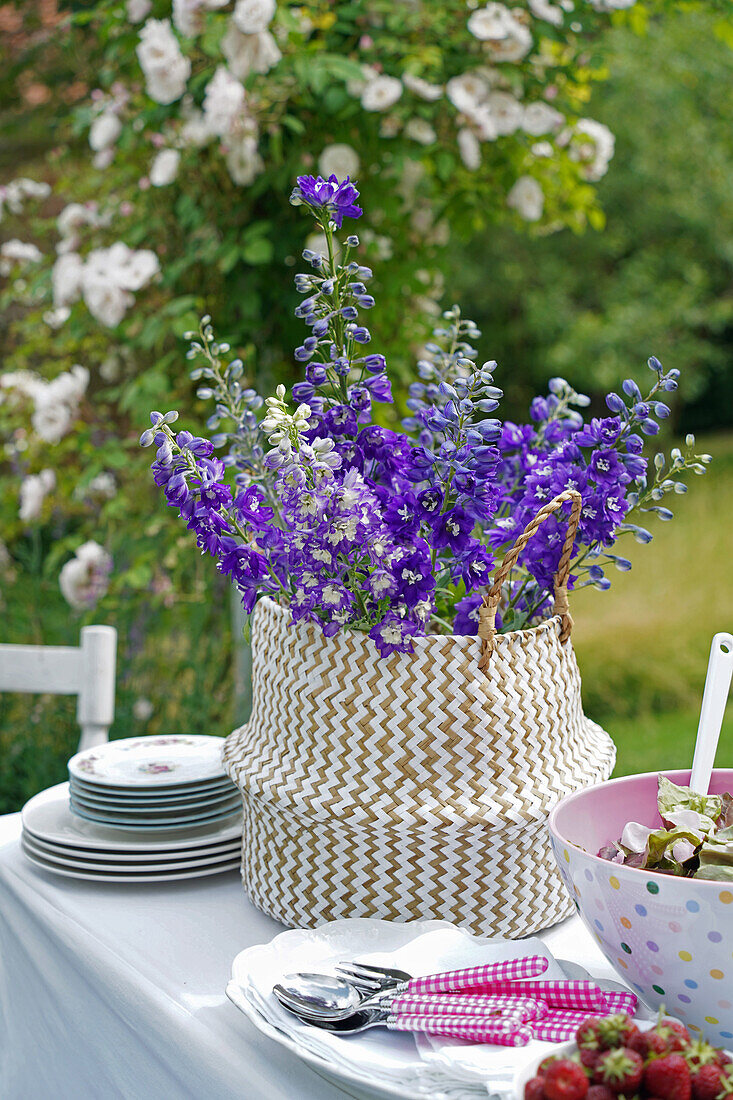 Garden party with delphinium in a woven basket