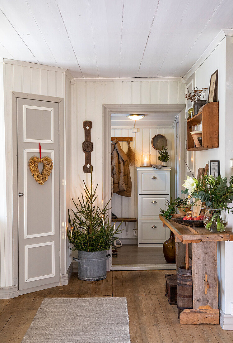 Entrance area with wood panelling, small Christmas tree and rustic wooden table