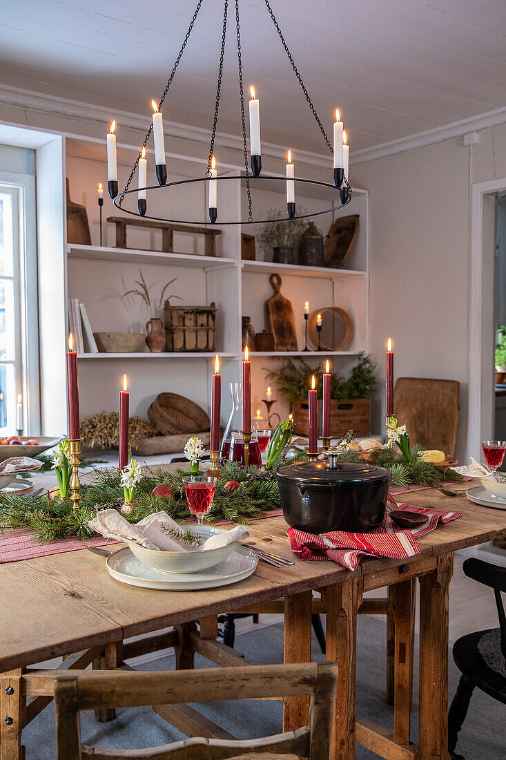 Festive dining table with candlesticks and shelf with rustic decorations