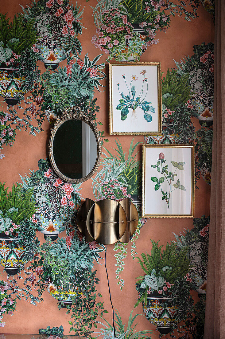 Patterned wallpaper with floral motifs and framed botanical prints on the wall