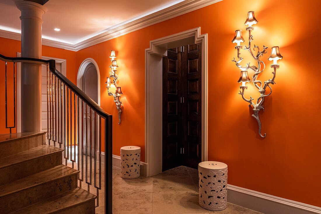 Hallway with symmetrical wall lights and orange-coloured walls