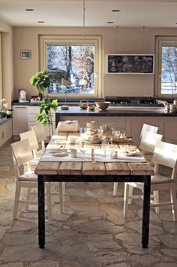 Helles Esszimmer und Küche mit Blick auf winterliche Landschaft