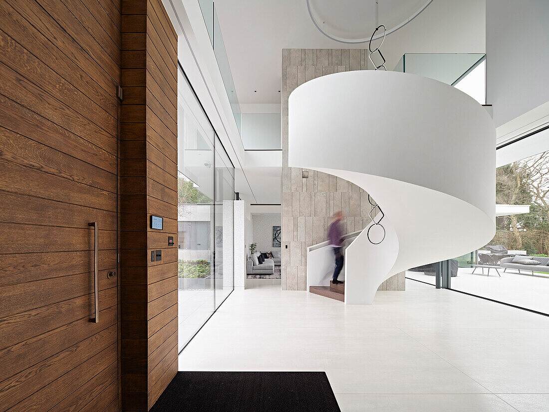 Generously designed entrance area with spiral staircase in the shape of a snail and wooden elements