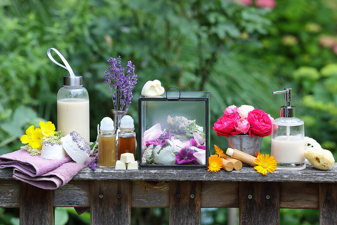 Natural cosmetics and flower arrangement on rustic wooden table in the garden