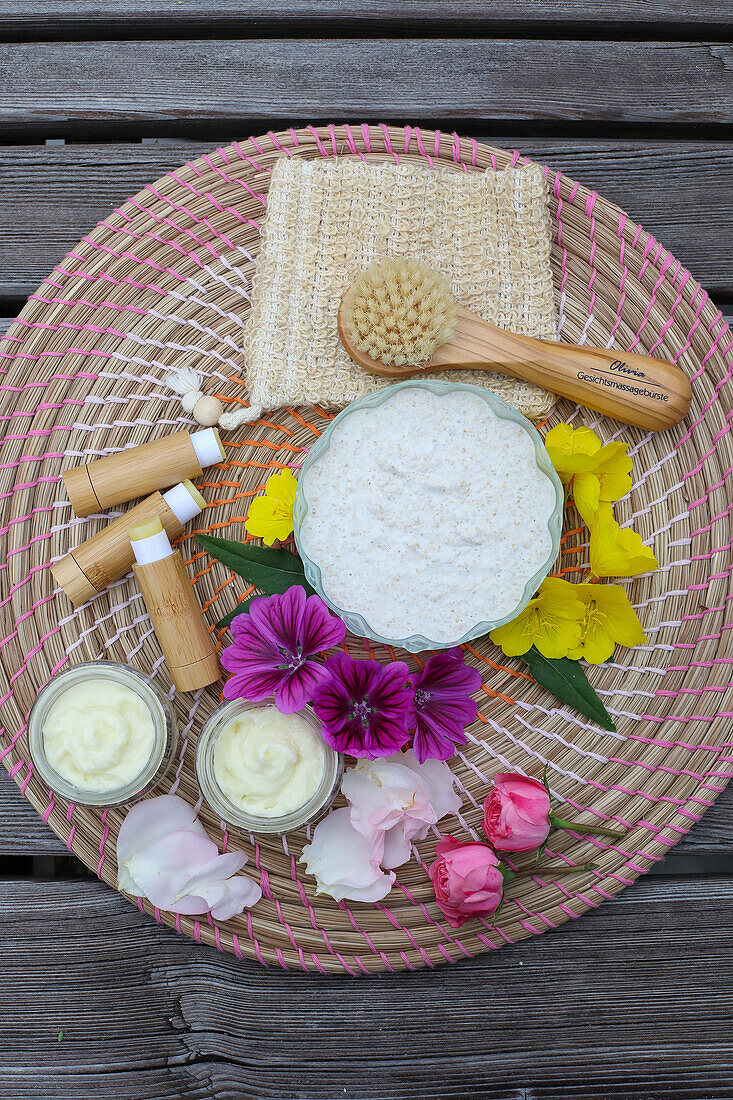 DIY-Hautpflege-Set mit Blüten und Naturprodukten auf geflochtener Unterlage