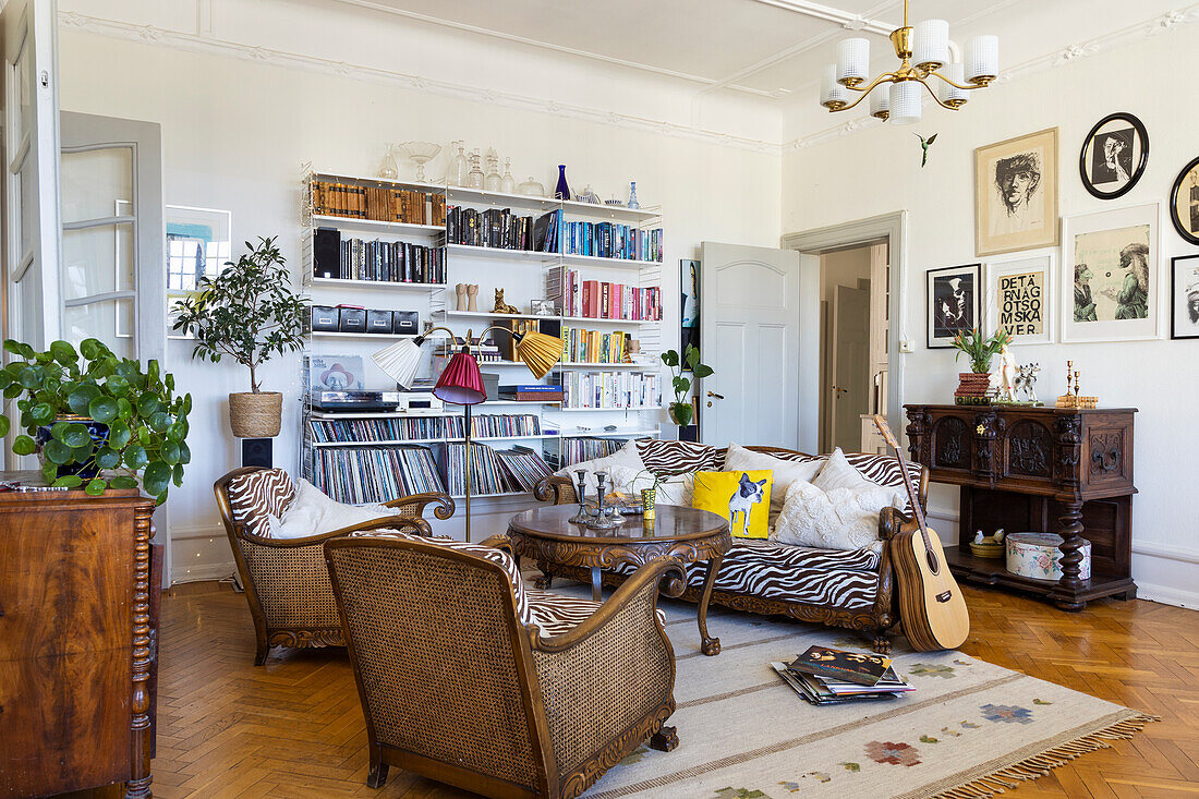 Living room with rattan armchairs, zebra pattern sofa and open bookshelf