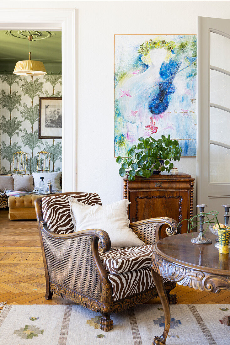 Armchair with zebra pattern and antique cabinet in elegant living room