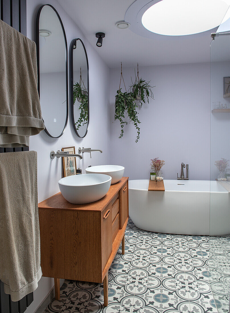 Bathroom with freestanding bathtub and patterned tiled floor