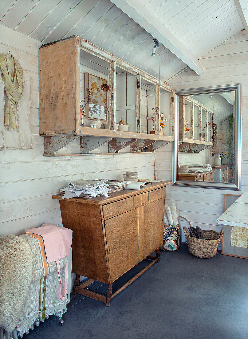 Rustic workroom with wooden cabinet and shelves made from recycled wood