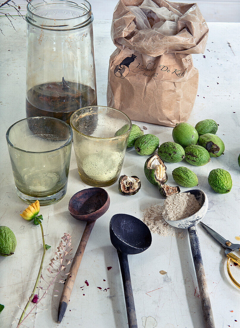 Herbs and walnuts with handmade wooden spoons on table