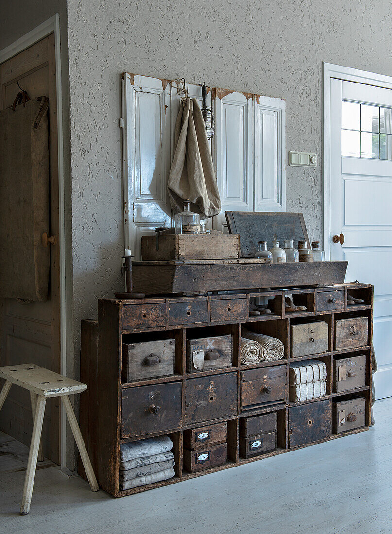 Vintage storage chest of drawers in dark wood with lots of drawers