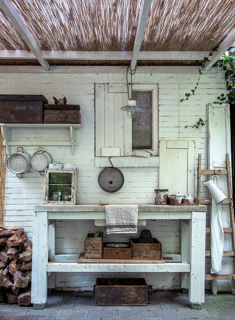 DIY outdoor kitchen under rattan canopy with vintage kitchen utensils