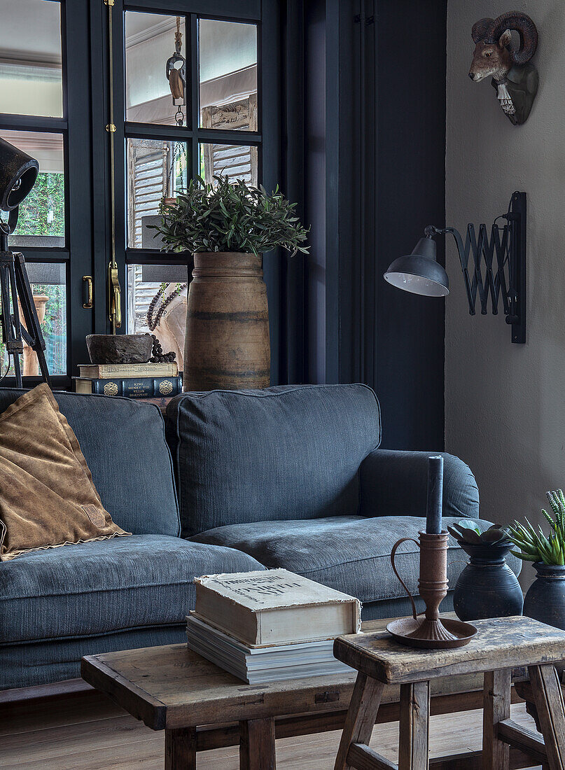 Blaues Samtsofa mit Holzmöbeln, Vintage-Dekor und Pflanzen im Wohnzimmer