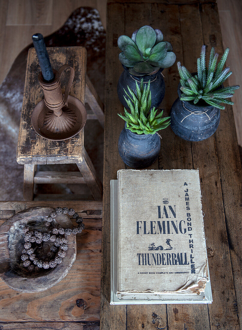 Table decoration with book, candle and succulents in ceramic vases