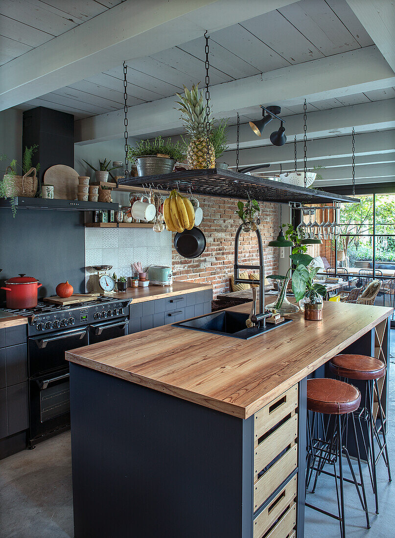 Modern kitchen with wooden beamed ceiling and free-standing wooden cooking island