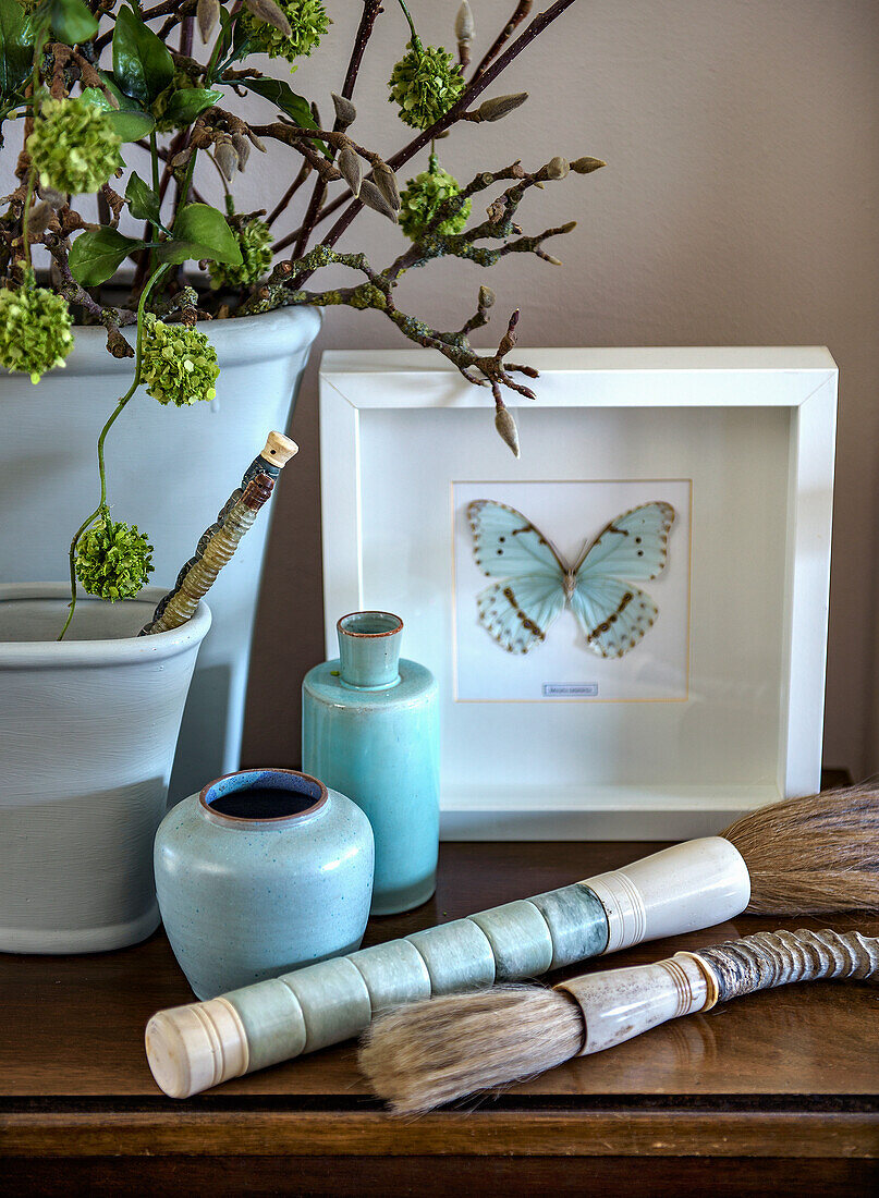 Decorative vases and butterfly picture on a wooden console