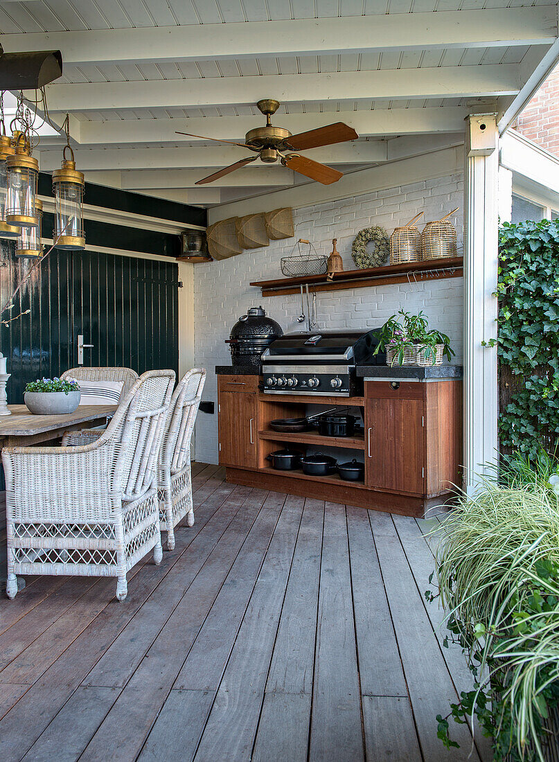 Covered terrace with dining area, ceiling fan and outdoor kitchen