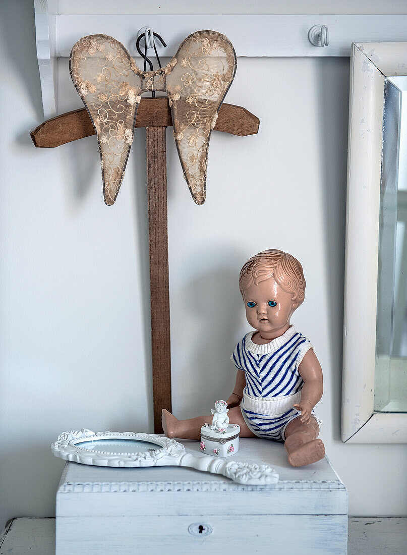 Vintage doll in sailor suit and hand mirror on bedside table