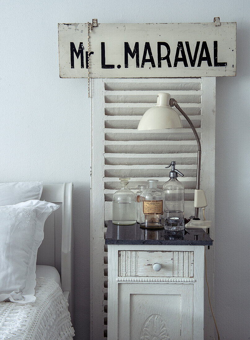 White bedside table with vintage decor and lamp in retro design