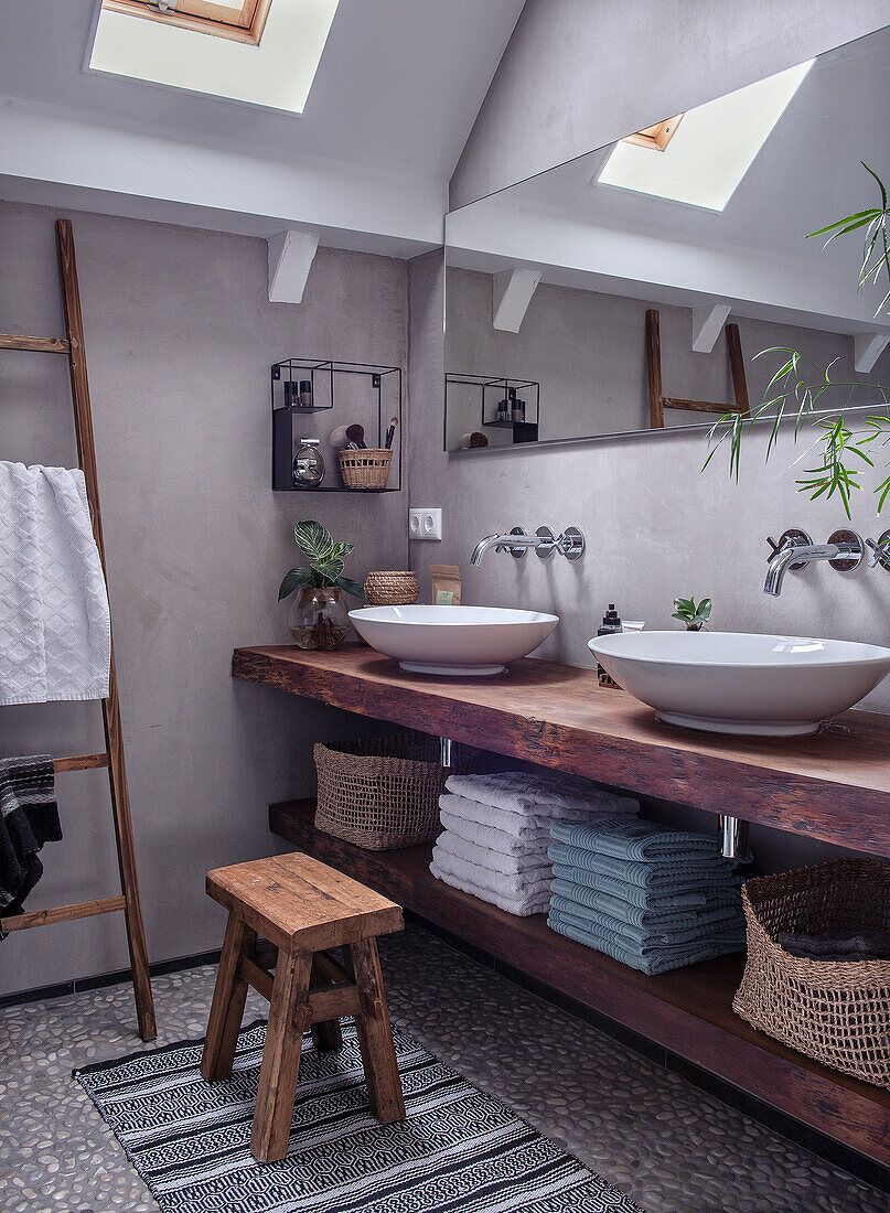 Bathroom with double sinks on a rustic wooden washstand and skylights