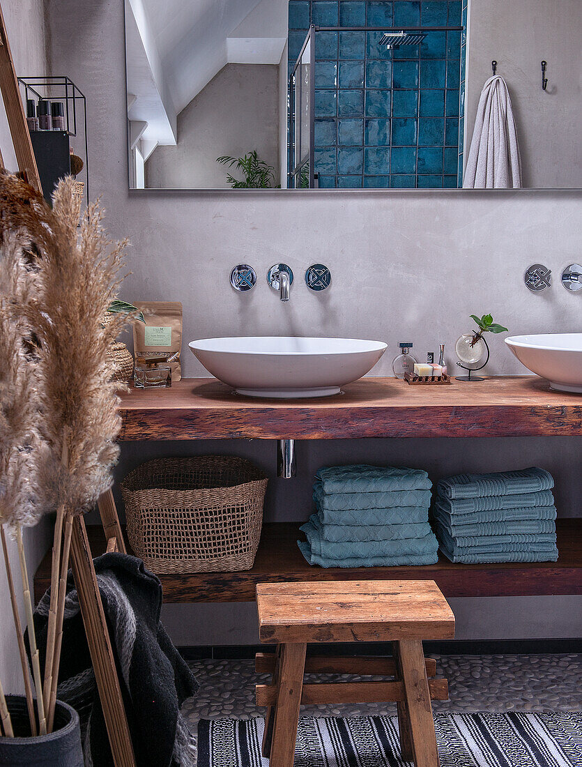 Modern bathroom with double sinks, blue tiles and wooden details