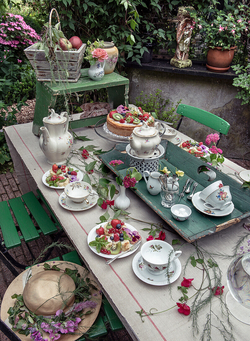 Laid garden table with vintage china surrounded by floral decorations