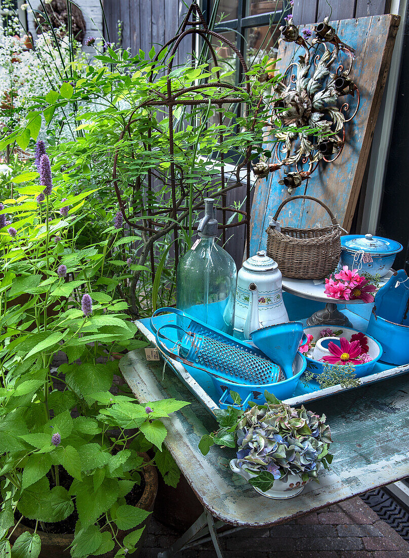 Blaue Vintage-Dekoration auf Tisch im Garten