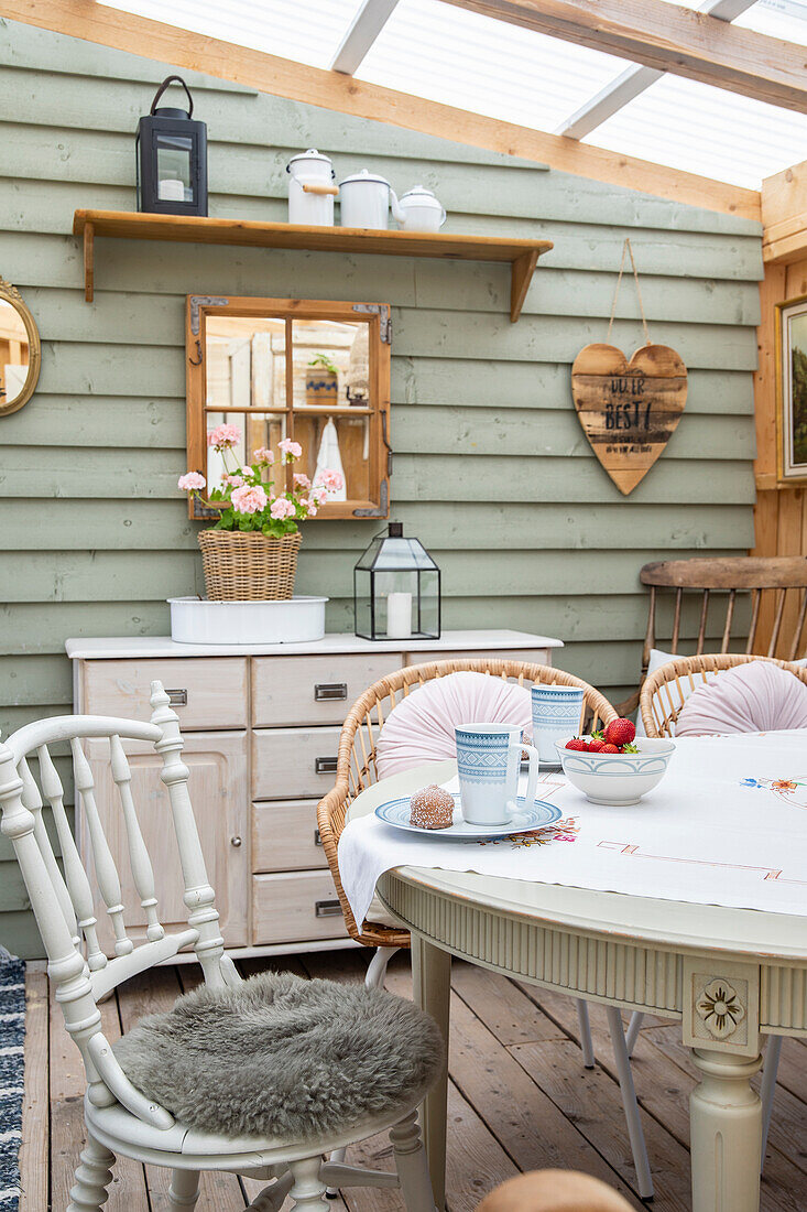 Dining area in garden shed with wooden and rattan furniture