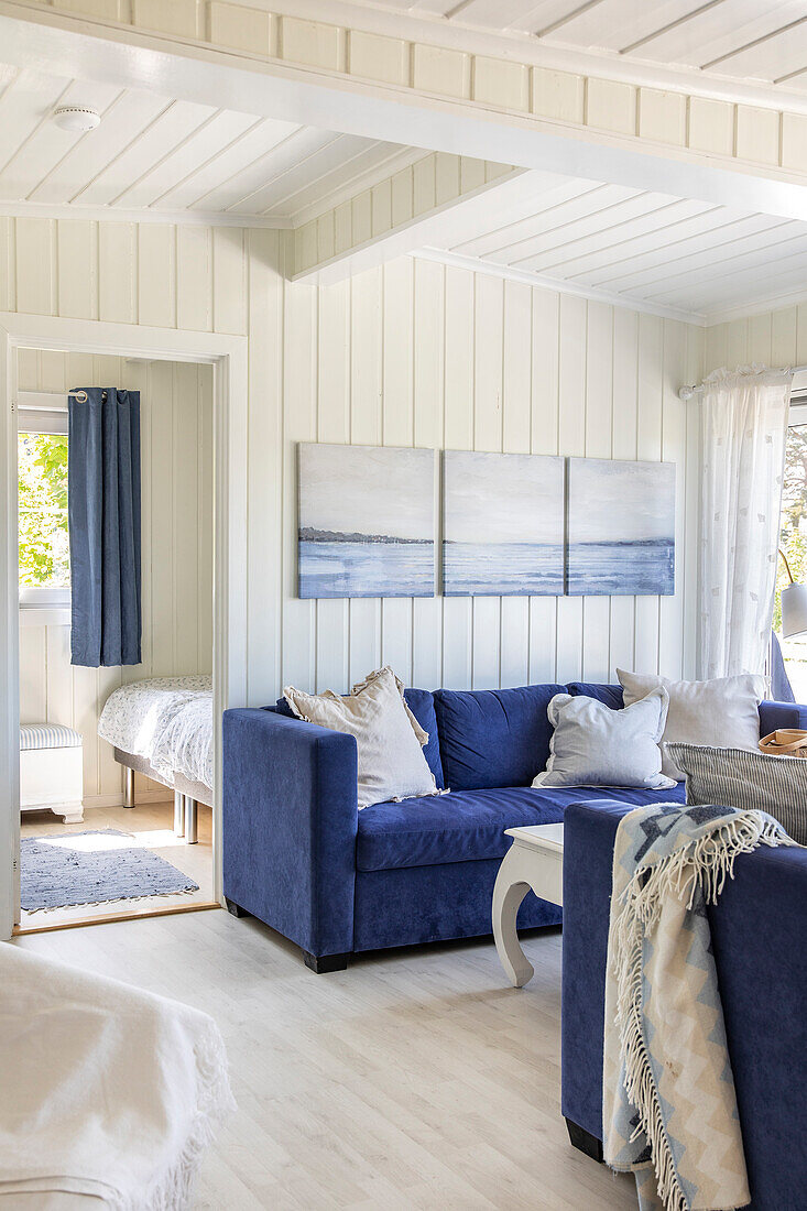 Living room with blue sofas and seascape painting on the wall