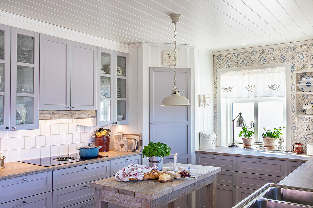 Light-coloured country kitchen with wooden worktops and reclaimed wood kitchen island