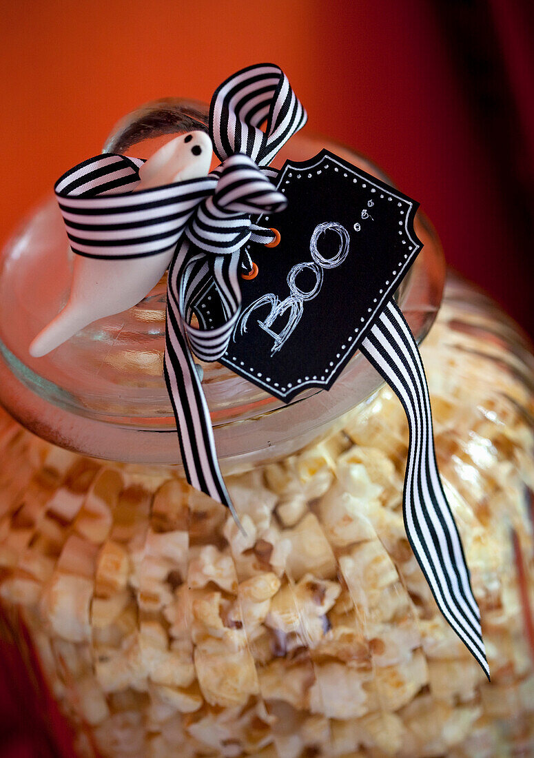 Popcorn in a glass container with Halloween decoration and "Boo" pendant