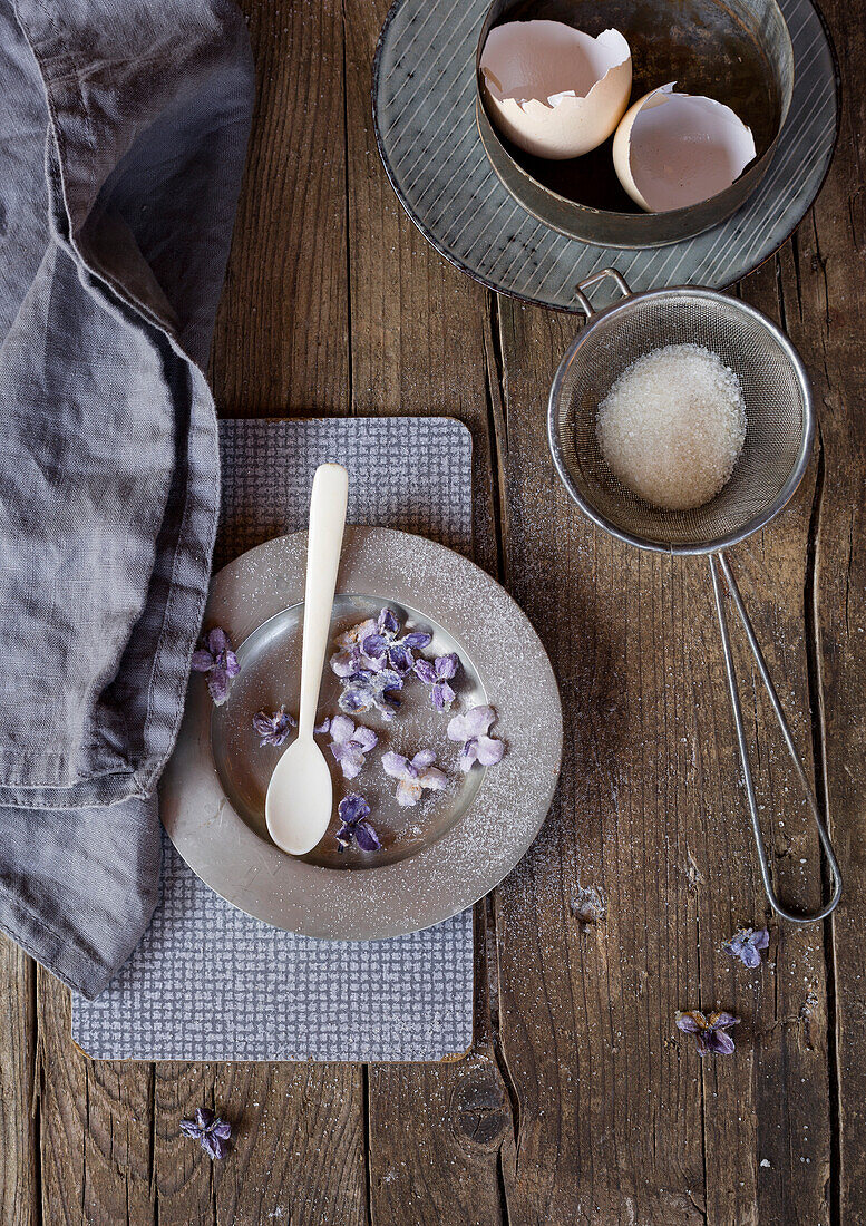 Sugar-coated lilacs and eggshells on a rustic wooden table