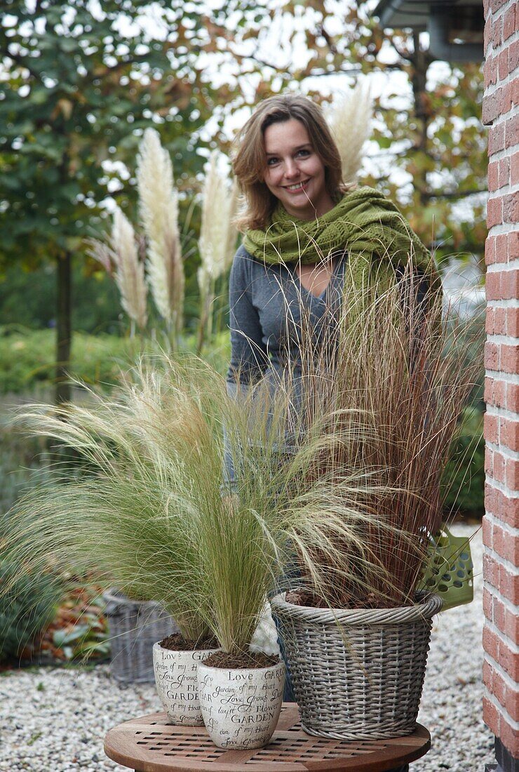 Woman standing by Ornamental grasses