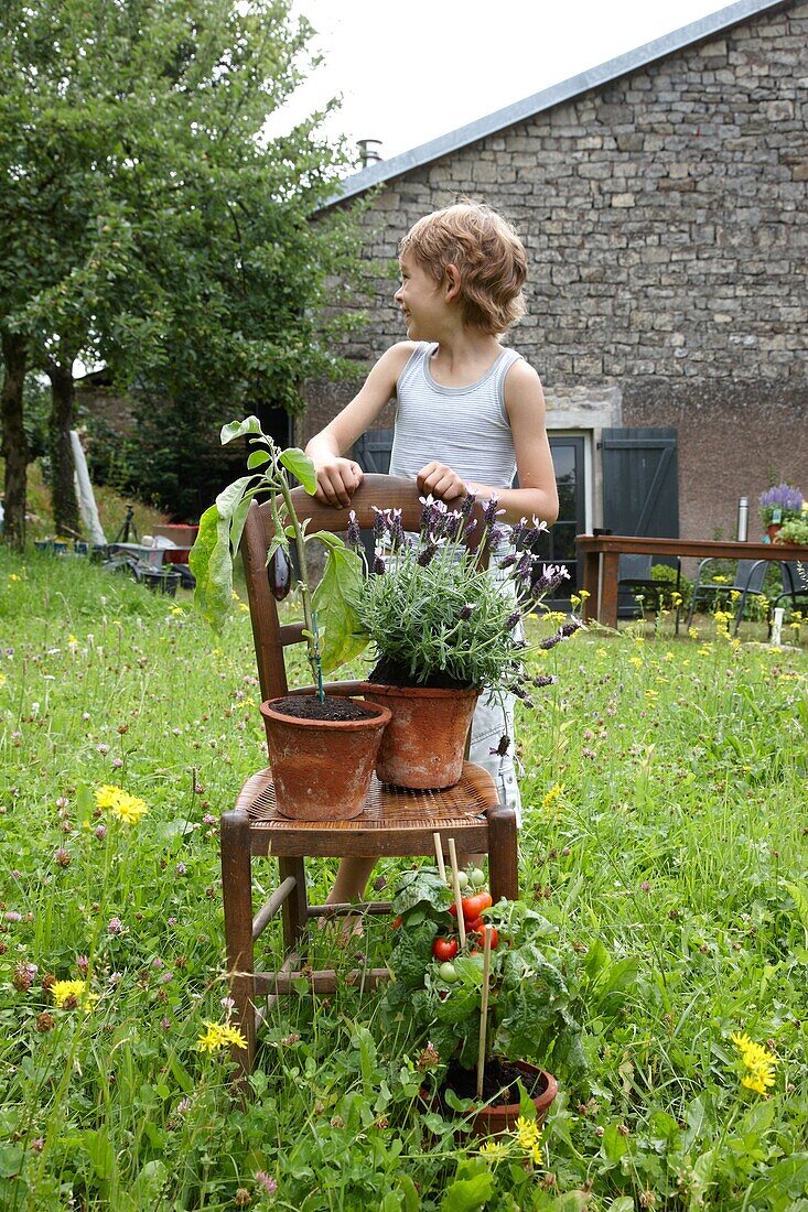 Boy standing by chair in garden