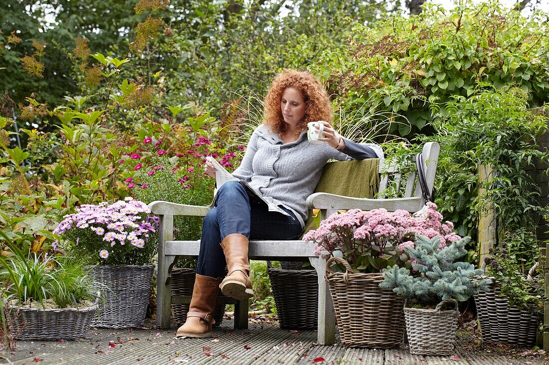 Frau entspannt sich auf einer Herbstterrasse