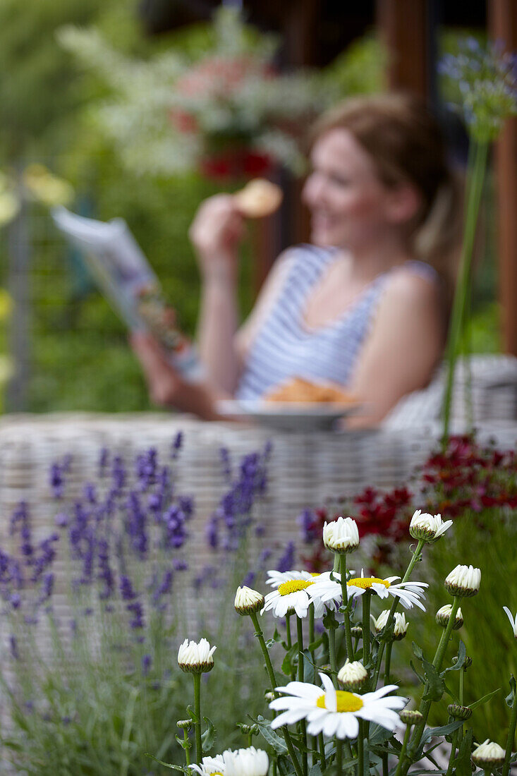 Frau liest auf der Terrasse