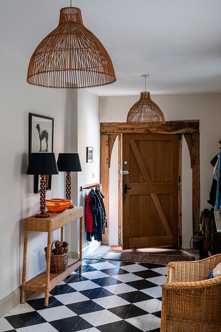 Entrance area with wicker furniture and black and white checkered wooden floor