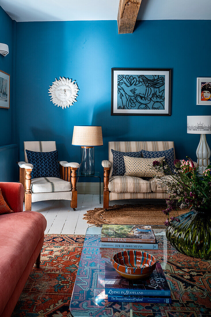 Living room with blue walls, antique chairs and patterned carpet