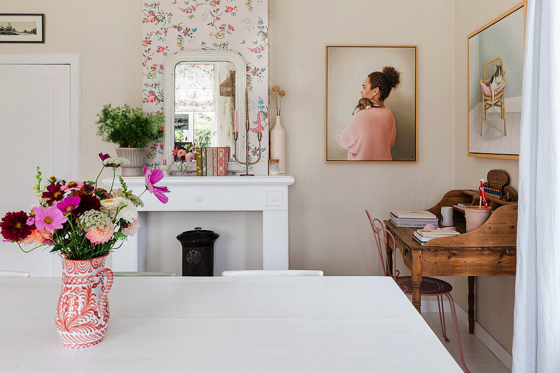 Dining room with floral pattern wallpaper and bouquet of flowers on wooden table