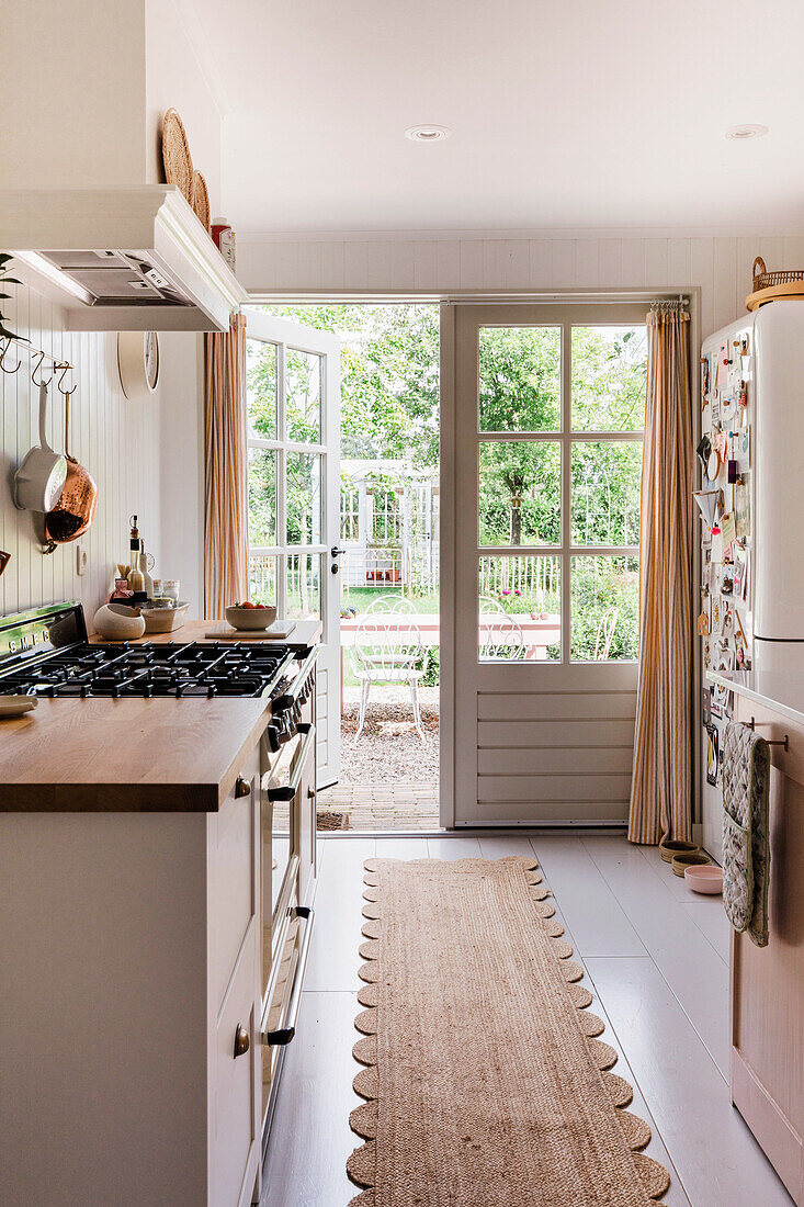 Landhausküche mit Holzarbeitsplatte und Blick in den Garten