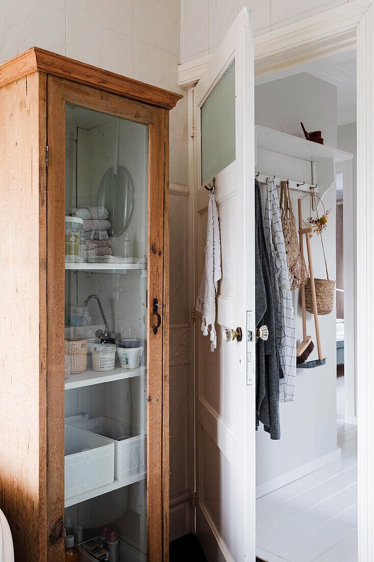 Eichenholz-Schrank mit Glasfront mit Blick in Besenkammer