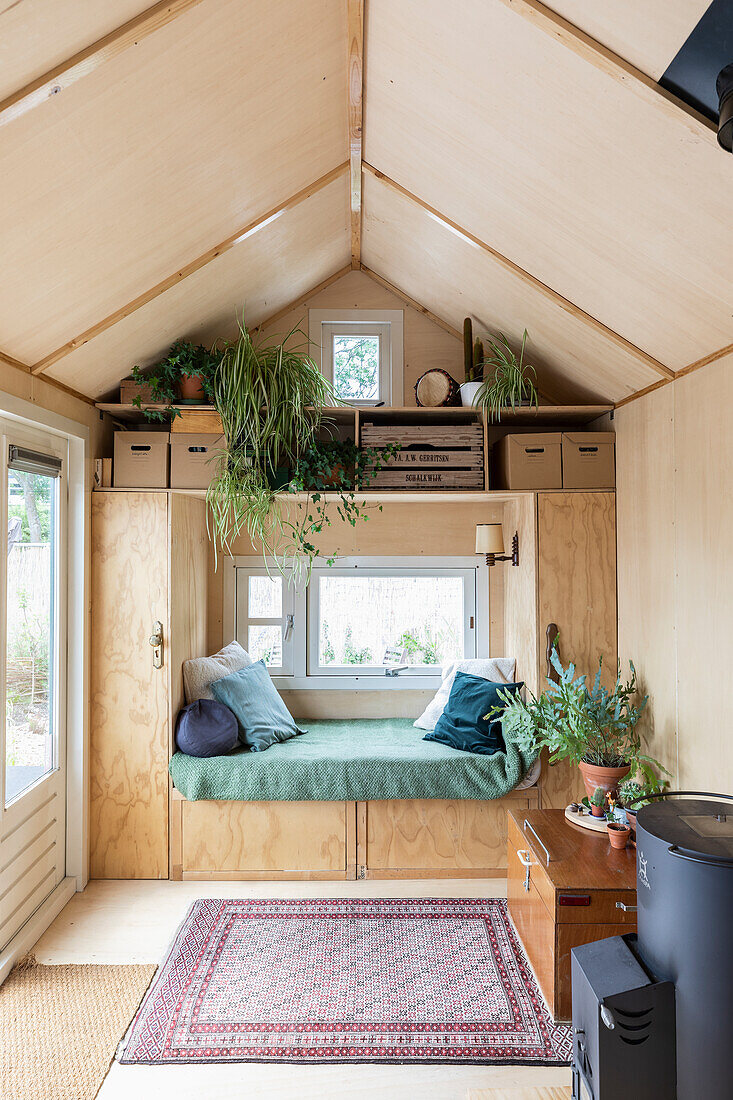 Gemütlicher Wohnbereich mit eingebauter Fensterbank und vielen Zimmerpflanzen