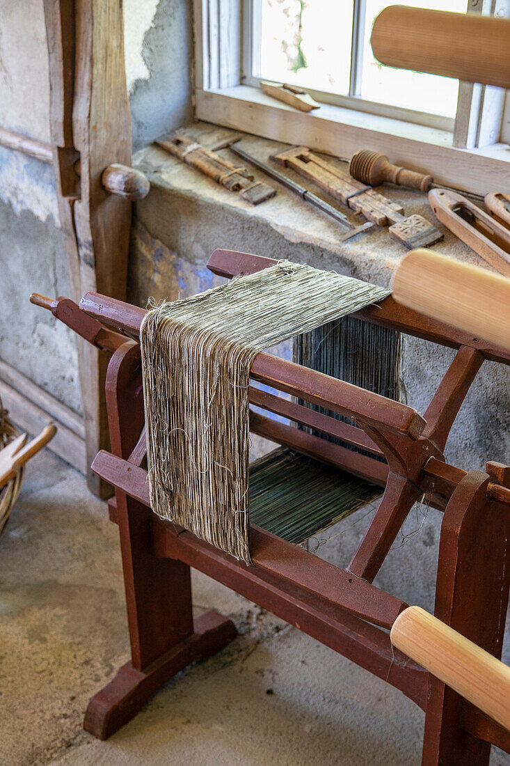 Traditional loom with linen fibres in a rustic room