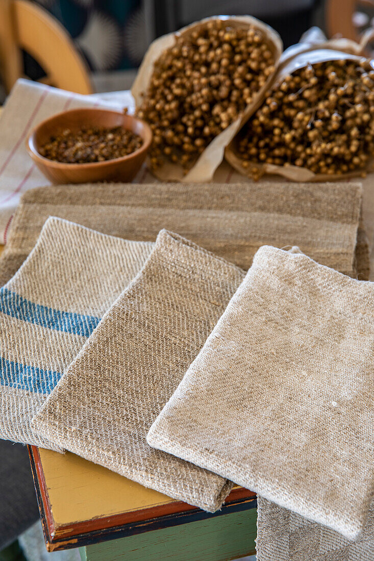 Linen cloths next to flax on a wooden table