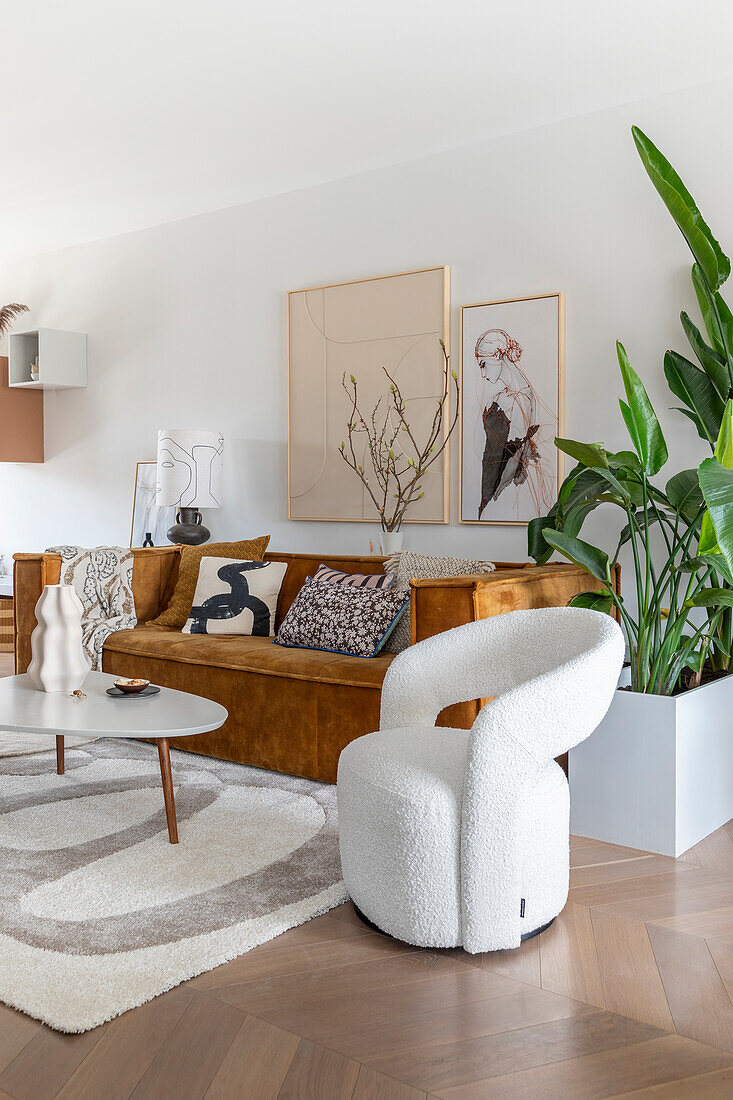 Modern living area with velvet sofa, designer chair and plants